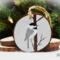 A handmade bird Christmas ornament with a hand-painted Carolina chickadee in the snow on a wood slice at Cove Creek Photography.